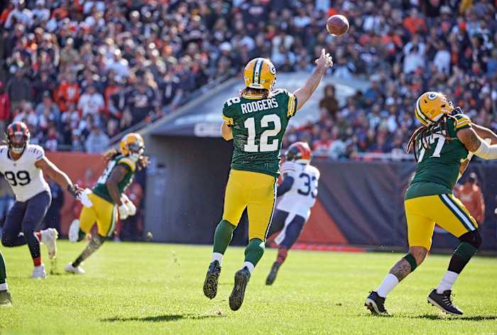 Aaron Rodgers throws downfield while both feet are off the ground during a game against the Bears